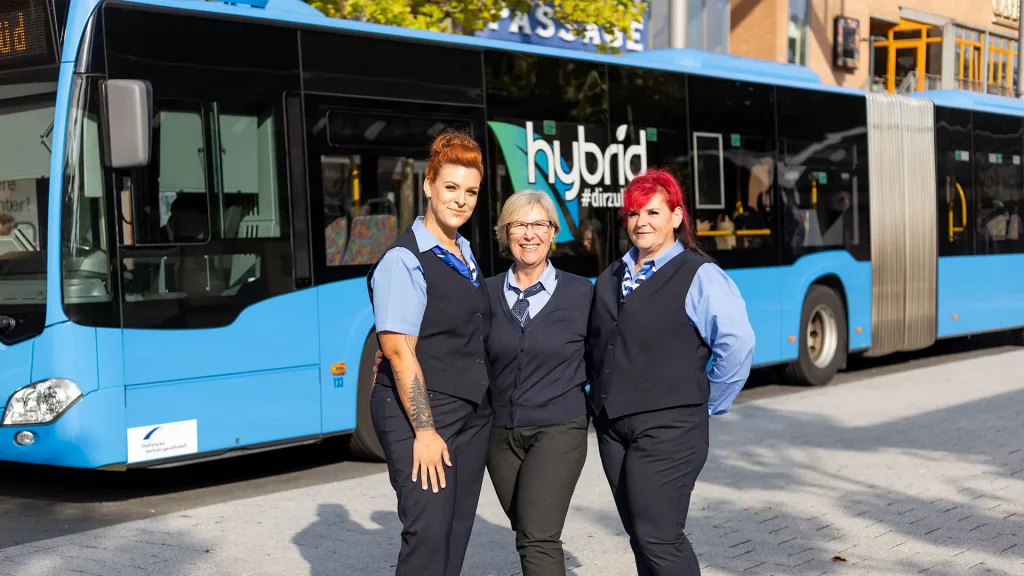 Drei Busfahrerinnen stehen vor einem blauen Bus der Stadtwerke Wilhelmshaven